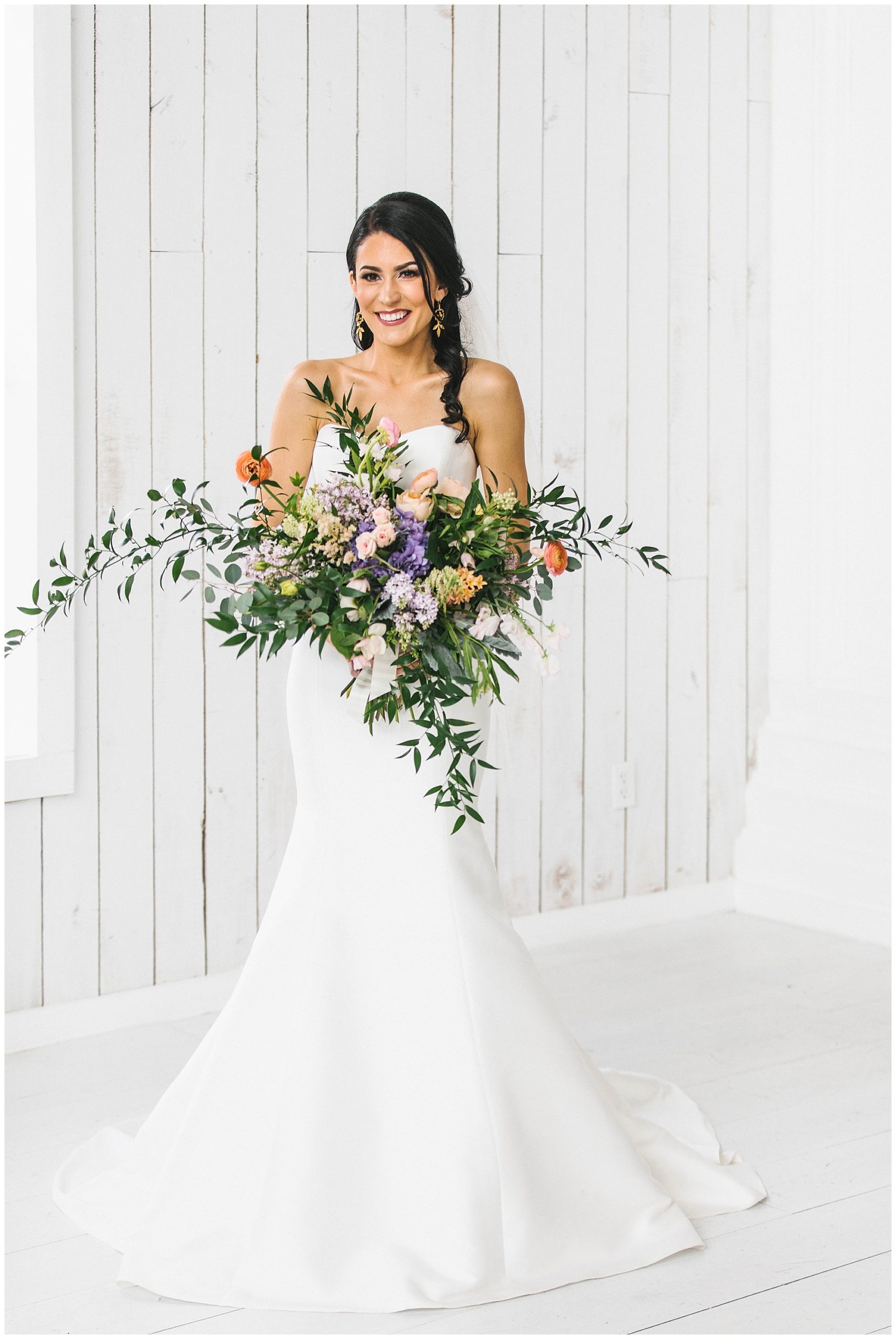 Dark-haired bride holding a lavish wedding floral.