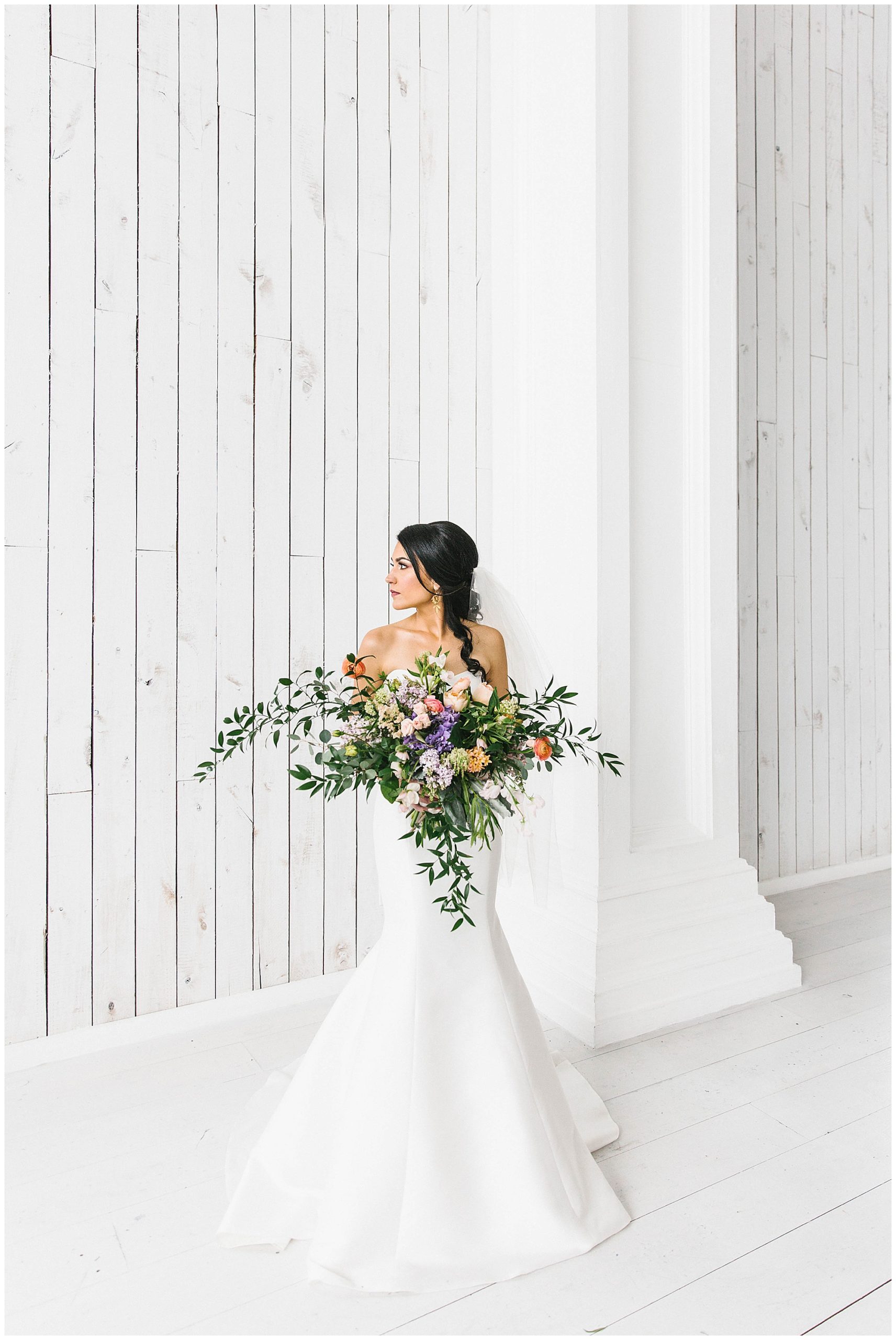 White Sparrow Bride looking off to the side holding her wedding bouquet.