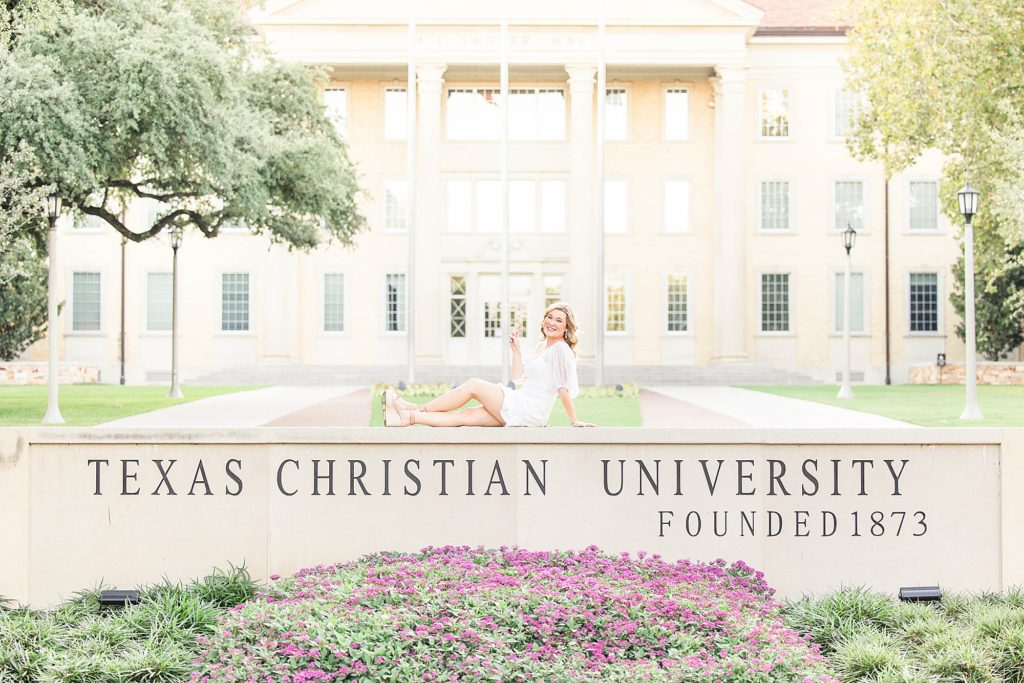 TCU Senior Sitting on TCU Sign