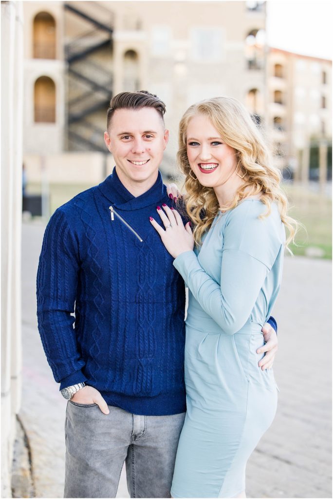 couple in blue outfits posing for their adriatica village engagement photos