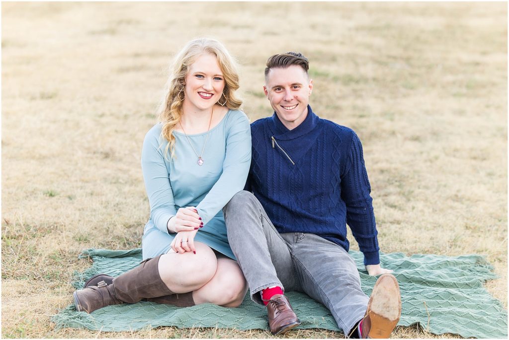 couple in blue outfits seated on lawn of adriatica village