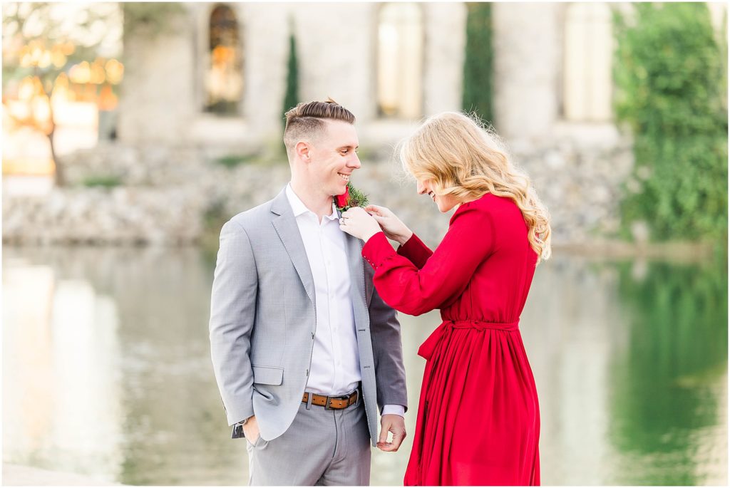girl pinning rose on her fiancé for their adriatica village engagement photos