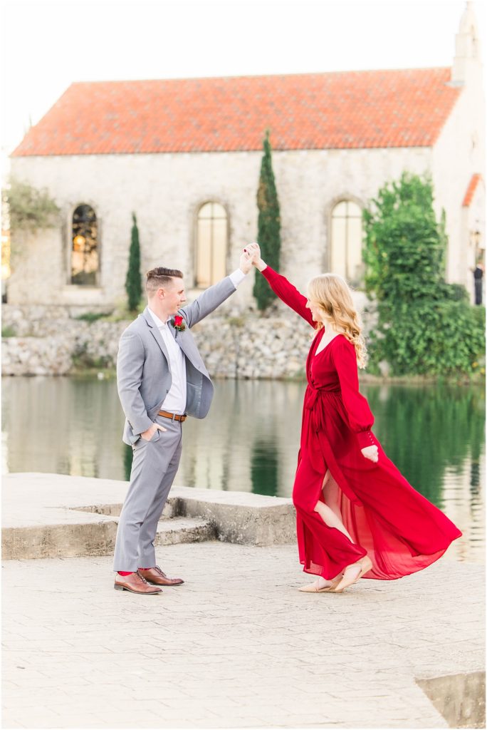 girl twirling in red dress for her adriatica village engagement photos