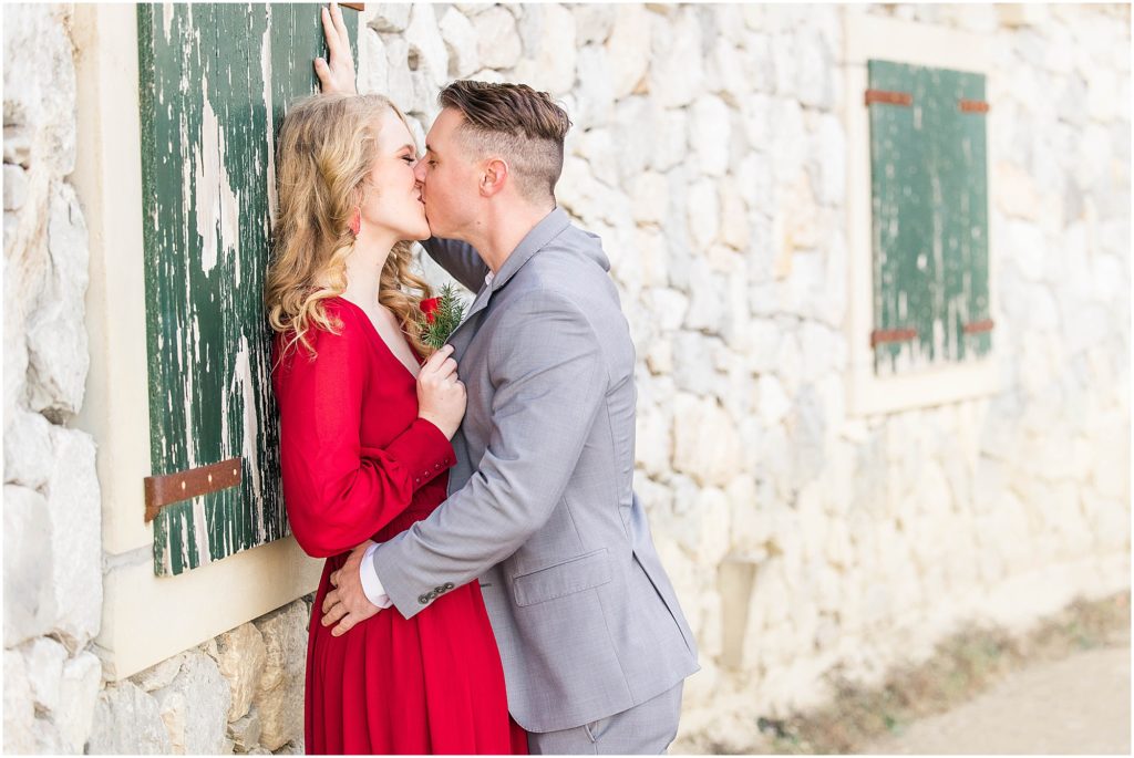 couple kissing in formal attire for their adriatica village engagement photos