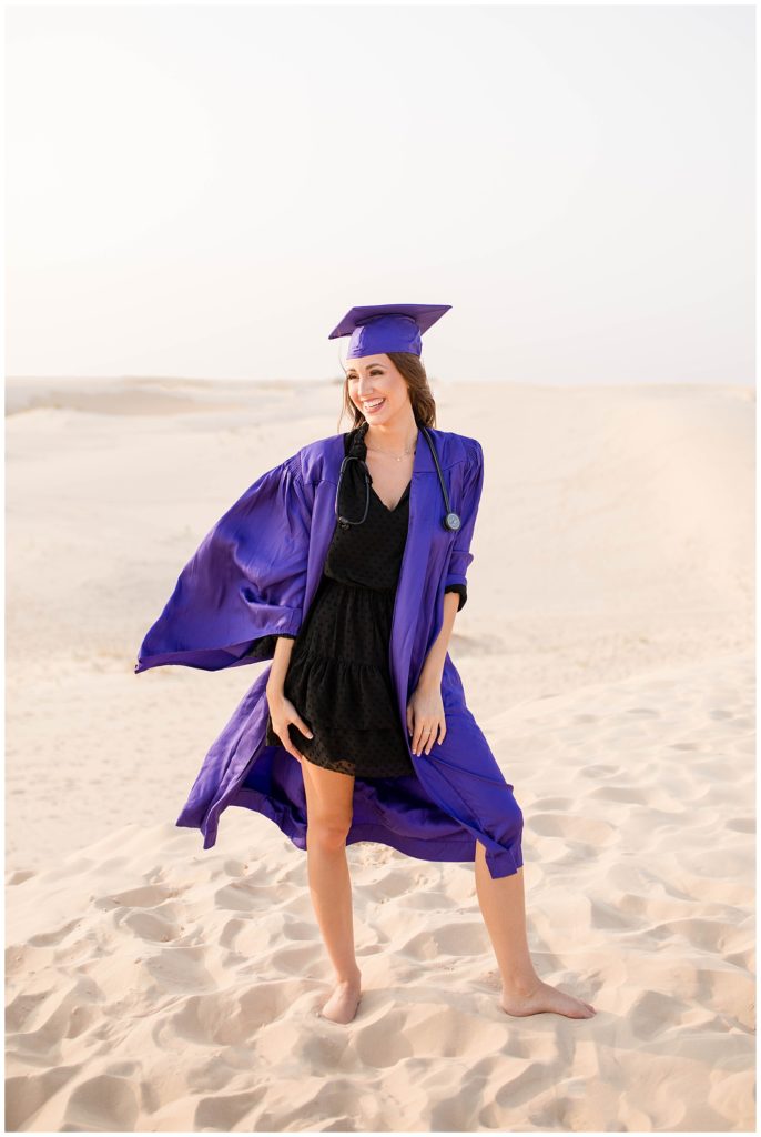 Girl in cap and gown at the sand dunes