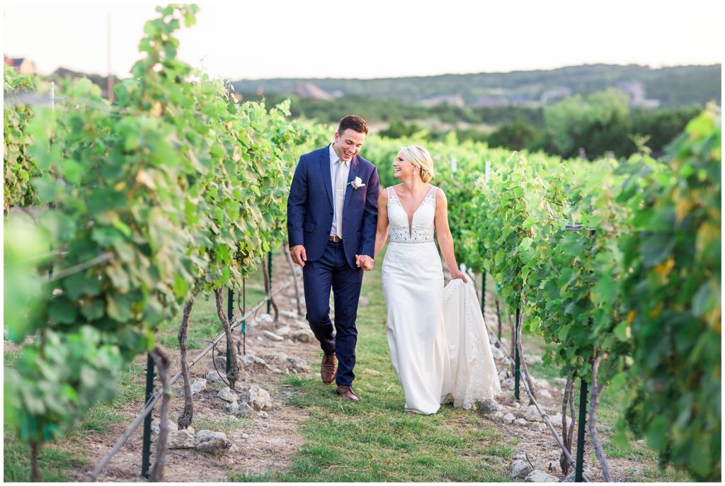 bride and groom walk hand-in-hand during portraits at their Dove Ridge Vineyard wedding
