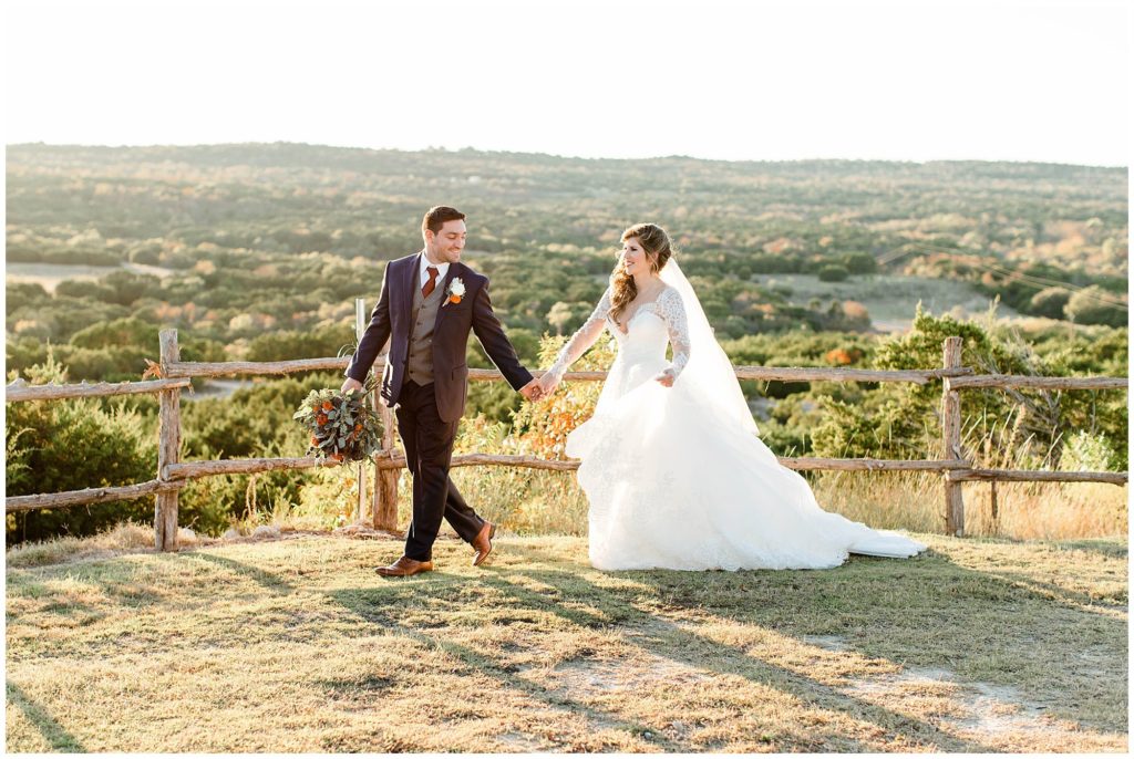 bride and groom walk together during their portraits with a scenic backdrop at Dove Ridge Vineyard